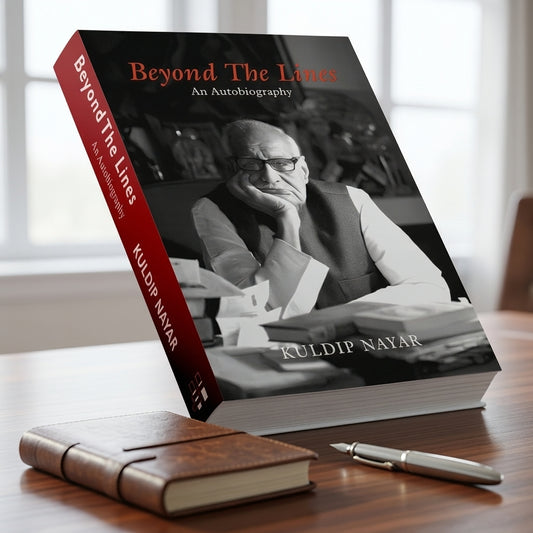 A hardcover autobiography book titled 'Beyond The Lines: An Autobiography' by Kuldip Nayar, shown standing open on a wooden table with a closed brown leather-bound copy and a silver pen in front. The book cover features a black-and-white portrait of the author and a red spine.